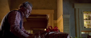 Movie still from “Apt Pupil” (1998), directed by Bryan Singer – An older man looking at a wrapped present; Close Up shot, Over the shoulder angle