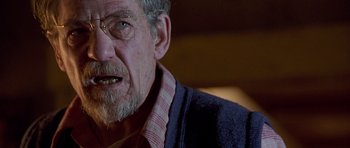 Movie still from “Apt Pupil” (1998), directed by Bryan Singer – An older man with a beard and glasses; Close Up shot, Over the shoulder angle