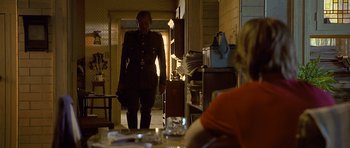 Movie still from “Apt Pupil” (1998), directed by Bryan Singer – A man in a military uniform walking down a hallway; Wide shot, Over the shoulder angle