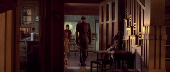 Movie still from “Apt Pupil” (1998), directed by Bryan Singer – A man in a uniform standing in a room; Wide shot, Low angle