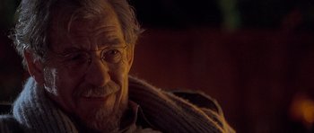 Movie still from “Apt Pupil” (1998), directed by Bryan Singer – An older man with a beard and glasses; Close Up shot, Over the shoulder angle