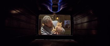 Movie still from “Apt Pupil” (1998), directed by Bryan Singer – An old man holding a cat in a fireplace; Medium shot, Low angle