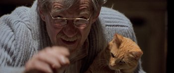 Movie still from “Apt Pupil” (1998), directed by Bryan Singer – An older man with glasses and a cat; Close Up shot, Low angle