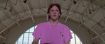 Movie still from “Apt Pupil” (1998), directed by Bryan Singer – A man in a pink shirt is standing in front of a window; Close Up shot, Low angle