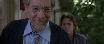 Movie still from “Apt Pupil” (1998), directed by Bryan Singer – An older man wearing glasses and a tie; Close Up shot, Over the shoulder angle