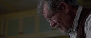 Movie still from “Apt Pupil” (1998), directed by Bryan Singer – An older man wearing glasses looking down at his face; Close Up shot, Low angle