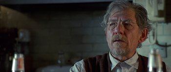 Movie still from “Apt Pupil” (1998), directed by Bryan Singer – An older man wearing glasses and a sweater; Close Up shot, Over the shoulder angle