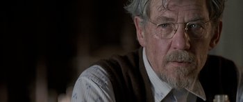 Movie still from “Apt Pupil” (1998), directed by Bryan Singer – An older man wearing glasses and a sweater vest; Close Up shot, Over the shoulder angle