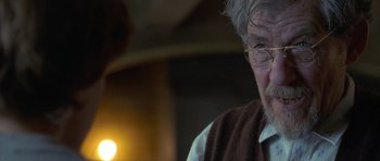 Movie still from “Apt Pupil” (1998), directed by Bryan Singer – An older man wearing glasses and a brown vest; Close Up shot, Over the shoulder angle