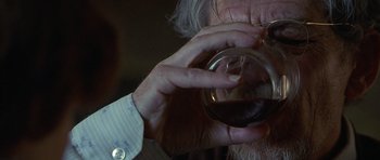 Movie still from “Apt Pupil” (1998), directed by Bryan Singer – An older man holding a glass of wine; Extreme Close Up shot, Over the shoulder angle