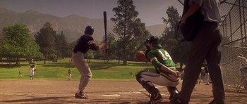 Movie still from “Apt Pupil” (1998), directed by Bryan Singer – A baseball player swinging a bat at a ball; Wide shot, Over the shoulder angle