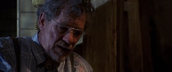 Movie still from “Apt Pupil” (1998), directed by Bryan Singer – An older man wearing glasses looking down at the floor; Close Up shot, Over the shoulder angle