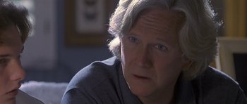 Movie still from “Apt Pupil” (1998), directed by Bryan Singer – An older man with gray hair looking at the camera; Close Up shot, Over the shoulder angle