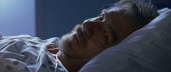 Movie still from “Apt Pupil” (1998), directed by Bryan Singer – A man with a beard laying in a bed; Close Up shot, High angle