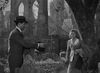 Movie still from “Arsenic and Old Lace” (1944), directed by Frank Capra – A man in a suit and a woman in a dress suit and a hat; Wide shot, High angle