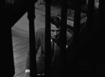 Movie still from “Arsenic and Old Lace” (1944), directed by Frank Capra – A black and white photo of a man talking on a cell phone; Medium shot, Low angle