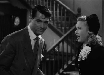 Movie still from “Arsenic and Old Lace” (1944), directed by Frank Capra – A man and a woman talking in front of a staircase; Medium shot, Over the shoulder angle