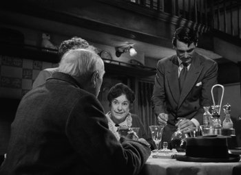 Movie still from “Arsenic and Old Lace” (1944), directed by Frank Capra – A group of people sitting at a table with wine glasses; Medium shot, Over the shoulder angle