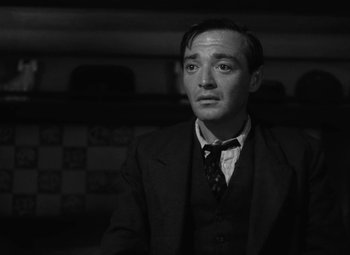 Movie still from “Arsenic and Old Lace” (1944), directed by Frank Capra – A black and white photo of a man in a suit and tie; Close Up shot, Low angle