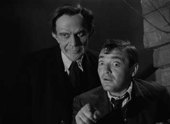 Movie still from “Arsenic and Old Lace” (1944), directed by Frank Capra – A black - and - white photo of two men in suits; Close Up shot, Low angle