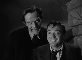 Movie still from “Arsenic and Old Lace” (1944), directed by Frank Capra – A black - and - white photo of two men posing for a picture; Medium shot, Low angle