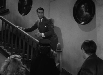 Movie still from “Arsenic and Old Lace” (1944), directed by Frank Capra – A black and white photo of a man on a staircase; Medium shot, High angle