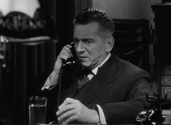 Movie still from “Arsenic and Old Lace” (1944), directed by Frank Capra – An older man talking on a phone while sitting at a table; Close Up shot, High angle