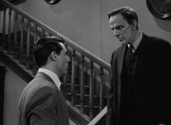 Movie still from “Arsenic and Old Lace” (1944), directed by Frank Capra – Two men in suits are standing in front of a staircase; Medium shot, Over the shoulder angle