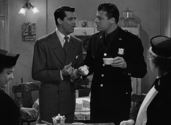 Movie still from “Arsenic and Old Lace” (1944), directed by Frank Capra – A couple of men standing next to each other at a table; Medium shot, Over the shoulder angle