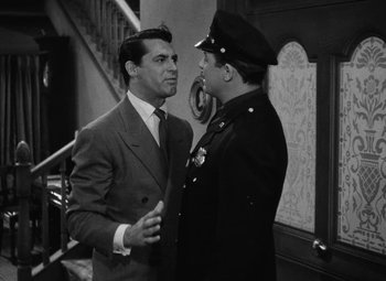 Movie still from “Arsenic and Old Lace” (1944), directed by Frank Capra – Two men in suits talking to each other in front of a staircase; Medium shot, Over the shoulder angle