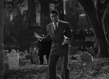 Movie still from “Arsenic and Old Lace” (1944), directed by Frank Capra – A black and white photo of a man in a cemetery; Wide shot, High angle