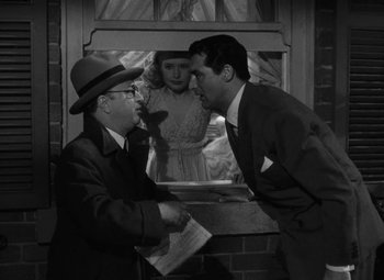 Movie still from “Arsenic and Old Lace” (1944), directed by Frank Capra – A man and a woman are talking to a man in a suit; Medium shot, Over the shoulder angle