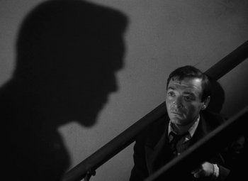 Movie still from “Arsenic and Old Lace” (1944), directed by Frank Capra – A black and white photo of a man in a suit and tie; Close Up shot, Low angle