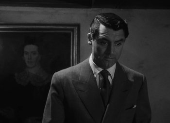 Movie still from “Arsenic and Old Lace” (1944), directed by Frank Capra – A man in a suit standing in front of a painting; Close Up shot, Over the shoulder angle