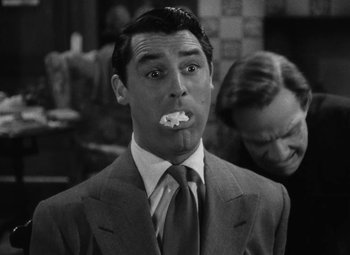 Movie still from “Arsenic and Old Lace” (1944), directed by Frank Capra – A man in a suit and tie brushing his teeth; Close Up shot, Over the shoulder angle