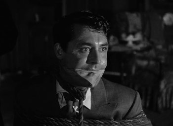 Movie still from “Arsenic and Old Lace” (1944), directed by Frank Capra – A black and white photo of a man in a suit and tie; Close Up shot, High angle