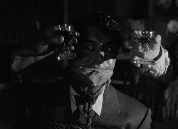 Movie still from “Arsenic and Old Lace” (1944), directed by Frank Capra – A black and white photo of a man in a suit and tie; Close Up shot, Over the shoulder angle