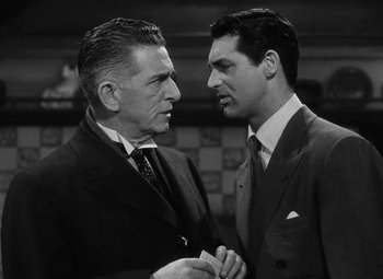 Movie still from “Arsenic and Old Lace” (1944), directed by Frank Capra – A black and white photo of two men in suits talking to each other; Close Up shot, Low angle