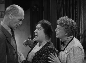 Movie still from “Arsenic and Old Lace” (1944), directed by Frank Capra – A group of people standing next to each other on a stage; Medium shot, Over the shoulder angle