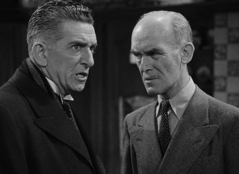 Movie still from “Arsenic and Old Lace” (1944), directed by Frank Capra – Two men in suits and ties talking to each other; Medium shot, Low angle