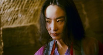 Movie still from “Ashes of Time” (1994), directed by Kar-Wai Wong – A woman with long black hair wearing a purple shirt; Close Up shot, Low angle