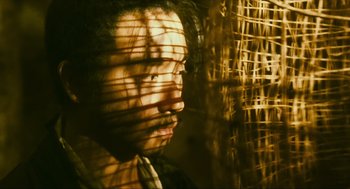 Movie still from “Ashes of Time” (1994), directed by Kar-Wai Wong – A man with long black hair is looking out of the blinds; Close Up shot, Low angle