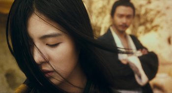 Movie still from “Ashes of Time” (1994), directed by Kar-Wai Wong – A woman with long black hair and a man with long hair; Close Up shot, Over the shoulder angle