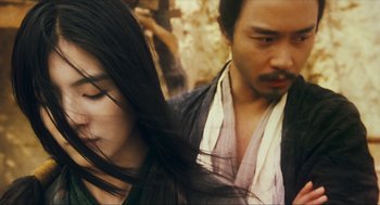 Movie still from “Ashes of Time” (1994), directed by Kar-Wai Wong – A man and a woman are walking in the street; Close Up shot, Over the shoulder angle