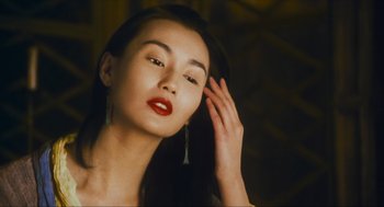 Movie still from “Ashes of Time” (1994), directed by Kar-Wai Wong – A woman with red lipstick is posing for a picture; Close Up shot, Low angle