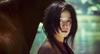 Movie still from “Ashes of Time” (1994), directed by Kar-Wai Wong – A young woman with black hair is posing for a picture; Close Up shot, Low angle