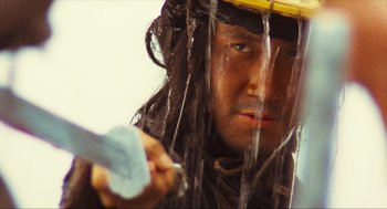 Movie still from “Ashes of Time” (1994), directed by Kar-Wai Wong – A man with a yellow hat is holding a knife; Close Up shot, Low angle
