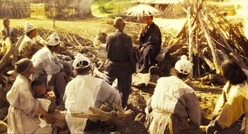 Movie still from “Ashes of Time” (1994), directed by Kar-Wai Wong – A group of men sitting on the ground in a field; Wide shot, High angle