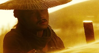 Movie still from “Ashes of Time” (1994), directed by Kar-Wai Wong – A man wearing a straw hat in the sun; Close Up shot, Low angle