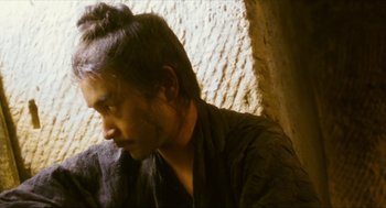 Movie still from “Ashes of Time” (1994), directed by Kar-Wai Wong – A man with long black hair is looking to his left; Close Up shot, Over the shoulder angle